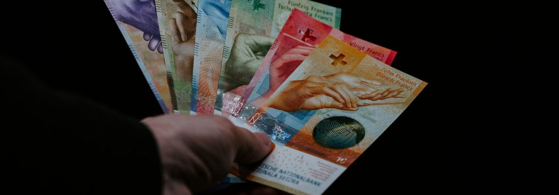 Ein Mann hält alle Banknoten des Schweizer Franken in der Hand.