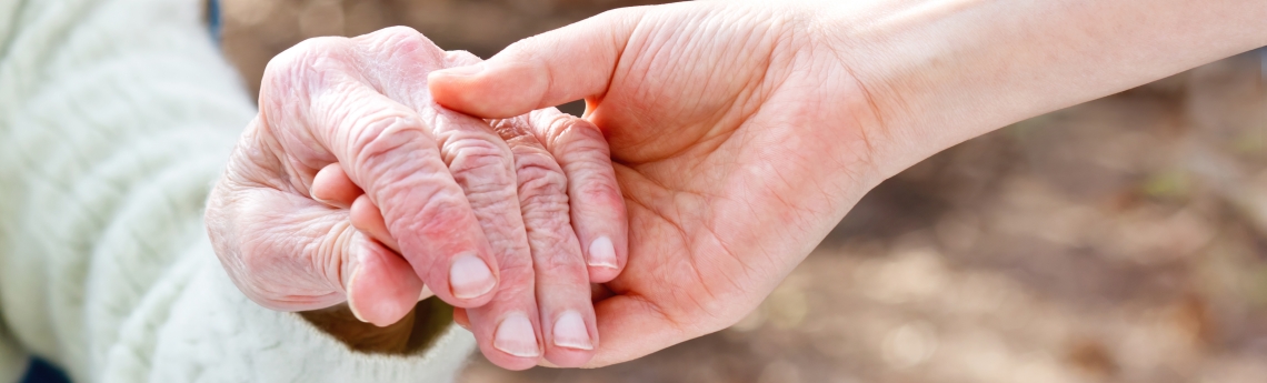 Ältere Frau hält Hand von junger Frau