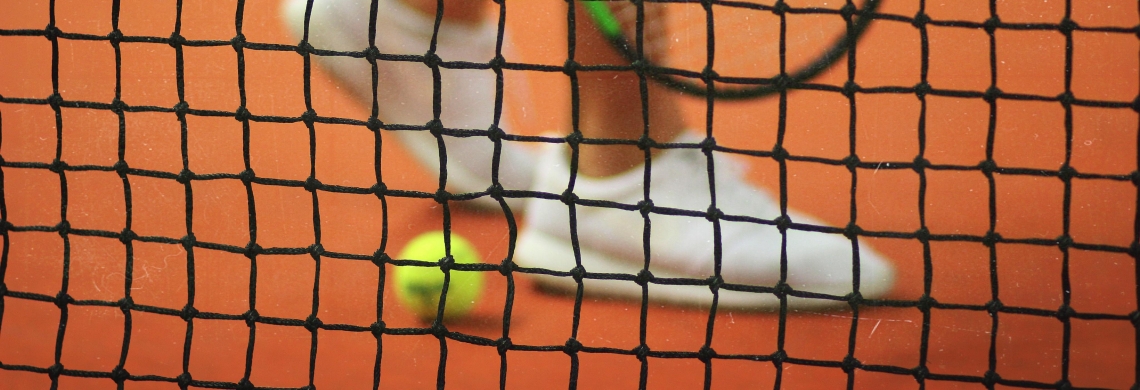Ein Tennisschläger und ein Tennisball mit einem Tennisnetz