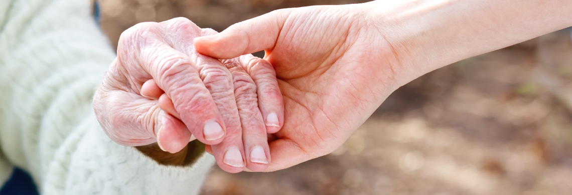 Hand einer älteren und einer jungen Person