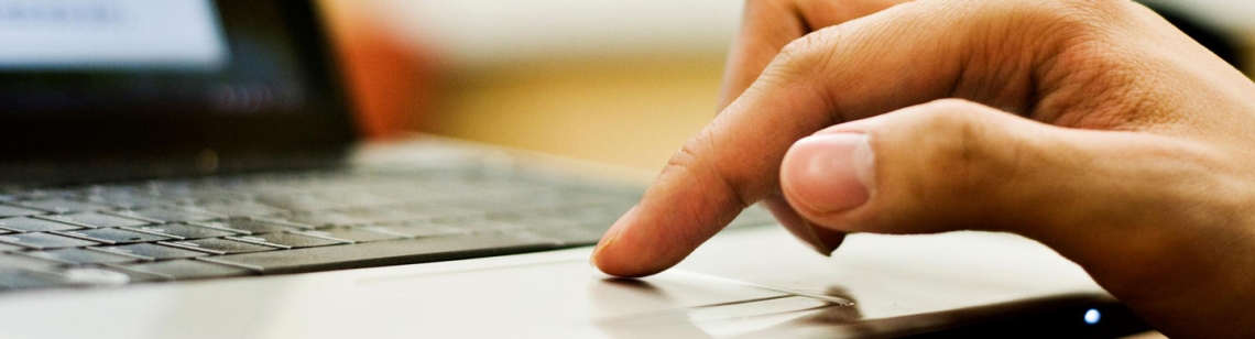 Symbolbild: Eine Hand über dem Touchpad eines Laptops