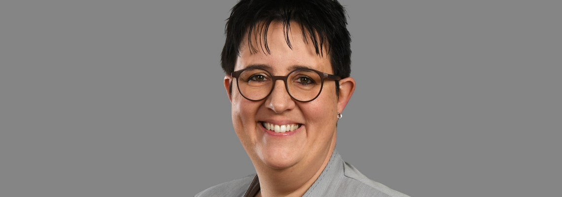 Franzsika Gschwend lacht in die Kamera, sie trägt eine Brille und hat dunkle Haare